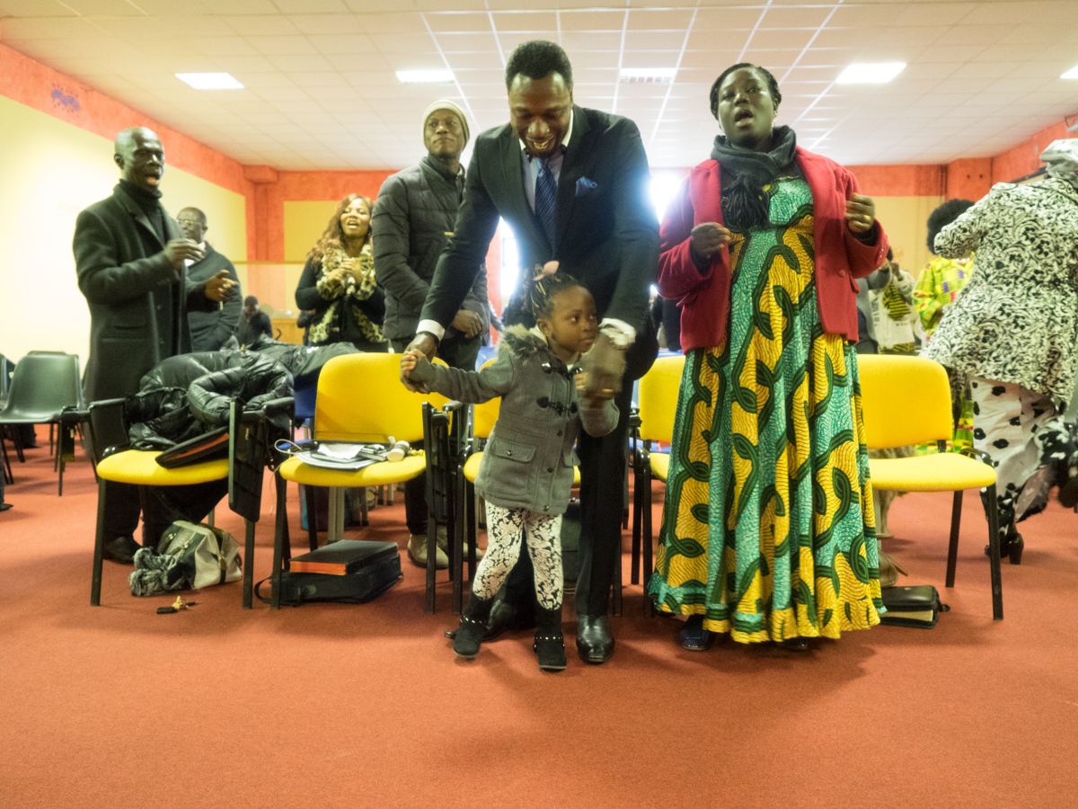 The pastor and his wife dance with a little girl